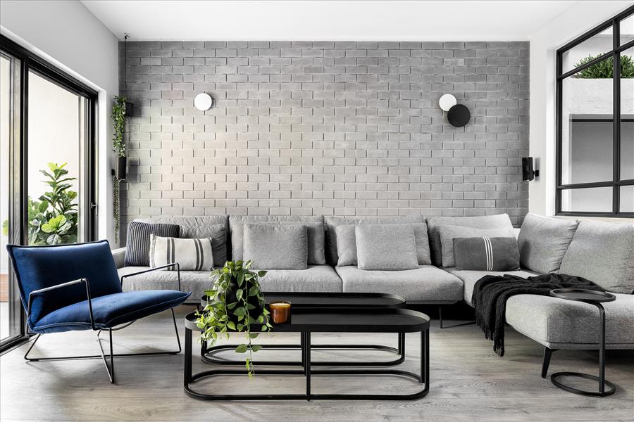 קיר הבריקים המקורי שהיה בסלון נשאר והועצם באמצעות תאורה