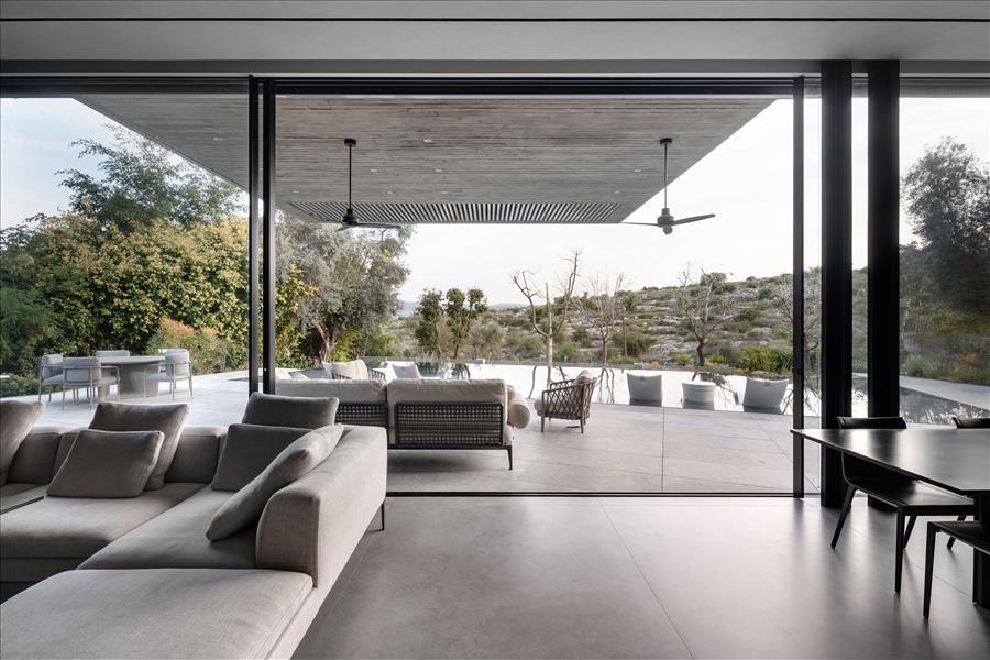 ממשיך את השפה החומרית האחידה של הבית.