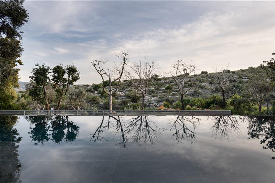 בריכה במנח שאינו מקביל לבית אלא מותאם לגבולותיו הטרפזיים של המגרש