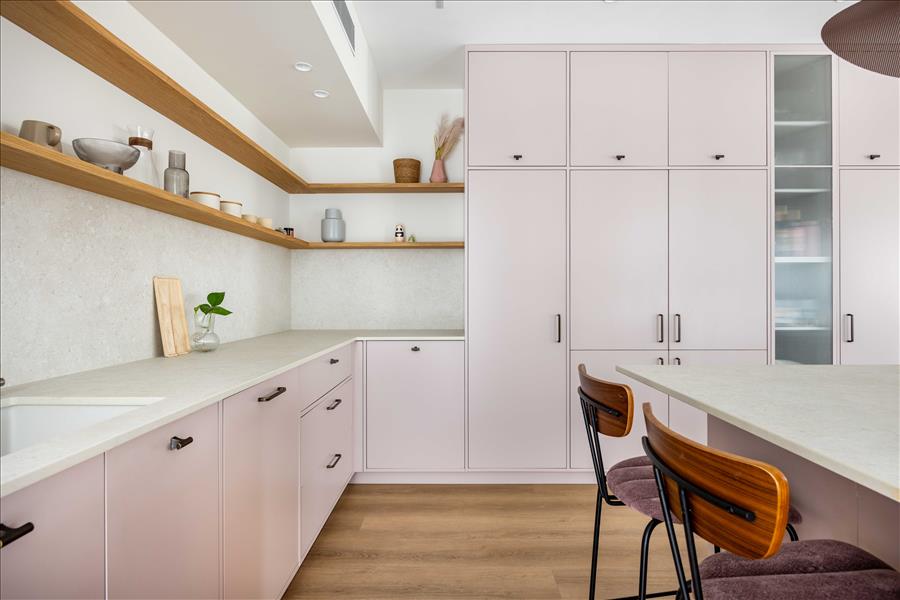 מדפים פתוחים מעץ אלון טבעי המשתלב בצורה נעימה עם הגוון הורוד 