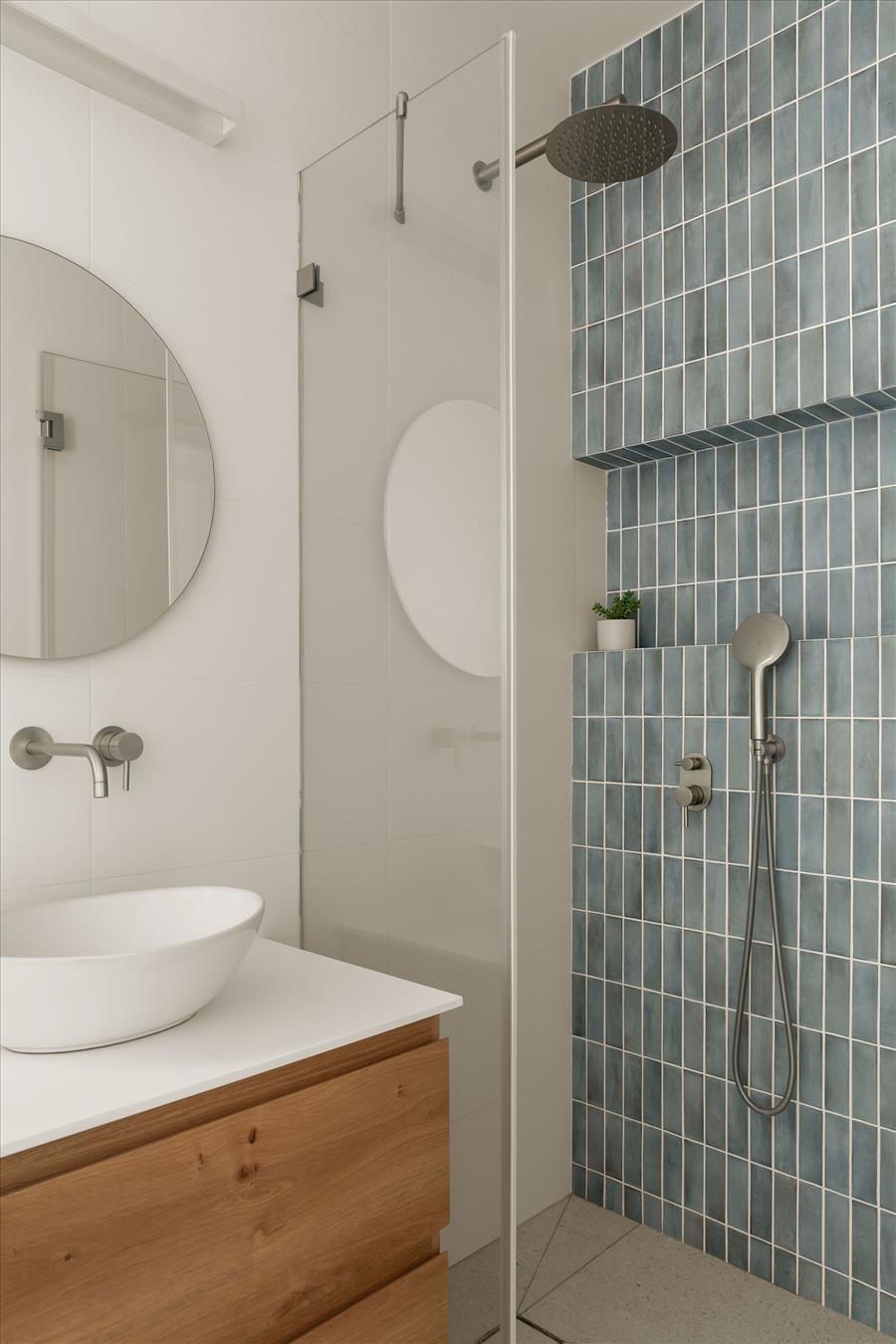 אריחים קטנים בגוון כחול-ירקרק מעושן שמוסיפים עומק מבלי להכביד