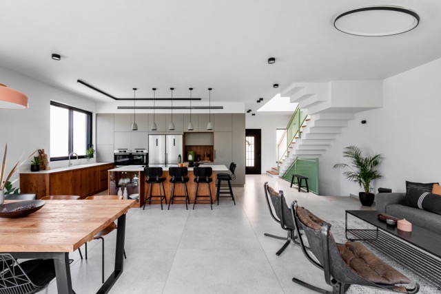 לצד המטבח שבמרכזה שולחן עץ גס במראה גולמי הנפתח לאורך של 3 מטרים